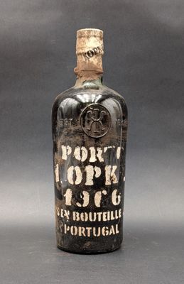 une vieille bouteille d'alcool bouchée avec un bouchon en liège, posée sur une table