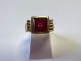 Gros plan sur une bague contenant une pierre rouge