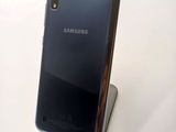 the back of a black samsung phone sitting on top of a metal stand