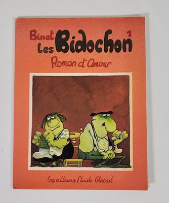 un livre orange sur lequel figure l'image d'un homme et d'une femme assis sur un banc