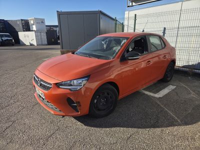 une voiture orange garée sur un parking à côté d'un immeuble