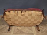 an old wooden bench with a red cushion on top of it