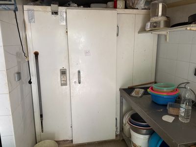 un réfrigérateur blanc dans une petite cuisine, à côté d'un évier