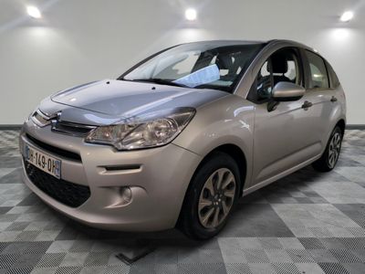 la petite voiture argentée est garée sur un carrelage à carreaux