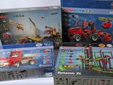 trois boîtes de legos de tailles et de couleurs différentes sur une surface blanche