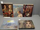 quatre livres exposés sur une table devant un mur gris