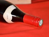 a bottle of wine that is on a red cloth