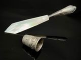 une cuillère en argent et un couteau posés sur une surface noire