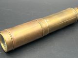 an old brass telescope on a black surface