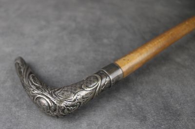 un gros plan d'un objet métallique muni d'un manche en bois, posé sur une surface grise