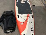 une planche de surf rouge et blanche posée par terre à côté d'autres bateaux