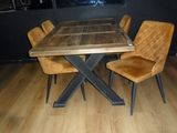 a wooden table with four chairs around it on a hard wood floor