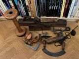 beaucoup de vieux outils par terre, devant une bibliothèque