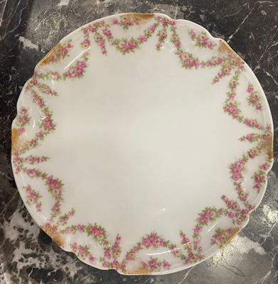 un gros plan d'une assiette blanche ornée de fleurs roses