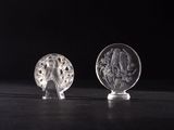 deux figurines en verre transparent posées sur une table noire