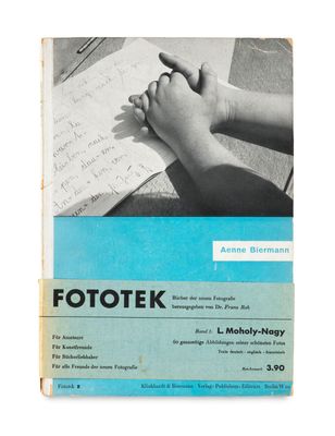 un vieux livre sur lequel on voit la main d'un enfant tenant un bout de papier