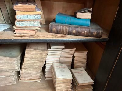 de nombreux livres anciens sur une étagère dans une pièce