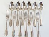 a lot of silver spoons and forks on the table