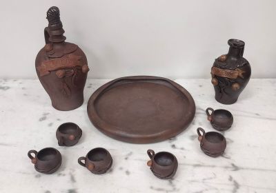 une table sur laquelle se trouvent un plateau, des tasses et une bouteille