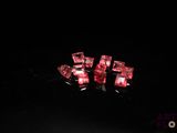 three pieces of red crystal sitting on top of a black surface