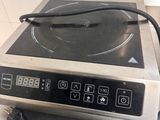 a silver stove top with a black burner on it