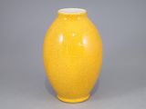 un vase jaune posé sur une table