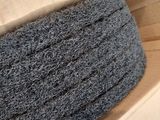 un sac en tricot gris posé sur une boîte en carton