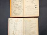 three open books with maps on them sitting on a table