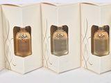 four empty boxes of perfume on a white surface with a blue ribbon