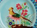 a colorful plate with a bird and flowers on it