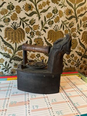 a black iron sitting on top of a table next to a calendar