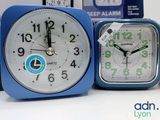 two alarm clocks sitting next to each other on a table