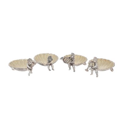 three silver figurines of a woman and a man on a shell