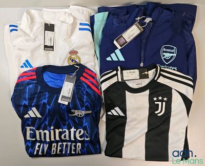 several soccer shirts are laid out on a white surface