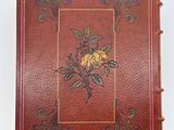 an old book with a picture of a rose on the cover