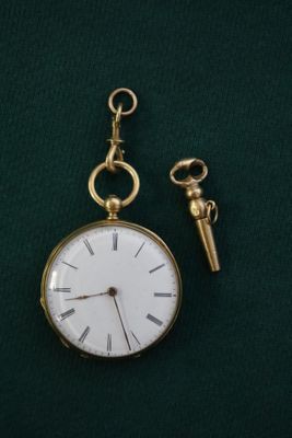 une montre de poche en or à laquelle est attachée une chaîne