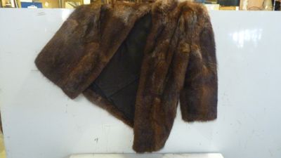 un manteau de fourrure marron accroché au mur d'un magasin