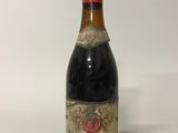 une vieille bouteille de vin posée sur une table blanche