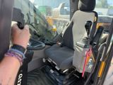 a person that is sitting in the driver ' s seat of a truck