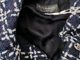 a close up of a chanel jacket with a tag on it