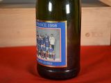 a bottle of wine sitting on a table with a picture on it