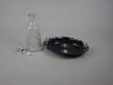 a small glass bottle and a small plate on the table