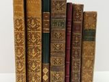 plusieurs vieux livres sont alignés sur une surface blanche