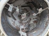an old cement mixer sitting on the grass