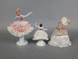 three figurines of a woman in a dress and a man in a tutu
