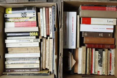 two boxes full of books sitting on the floor