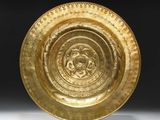a close up of a gold plate on a white surface