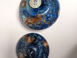 two blue and brown marble balls sitting on top of a white surface