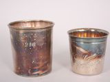 two silver cups sitting next to each other on a table