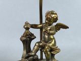 brass plated lamp with angel holding a bird and a lamp on a stand